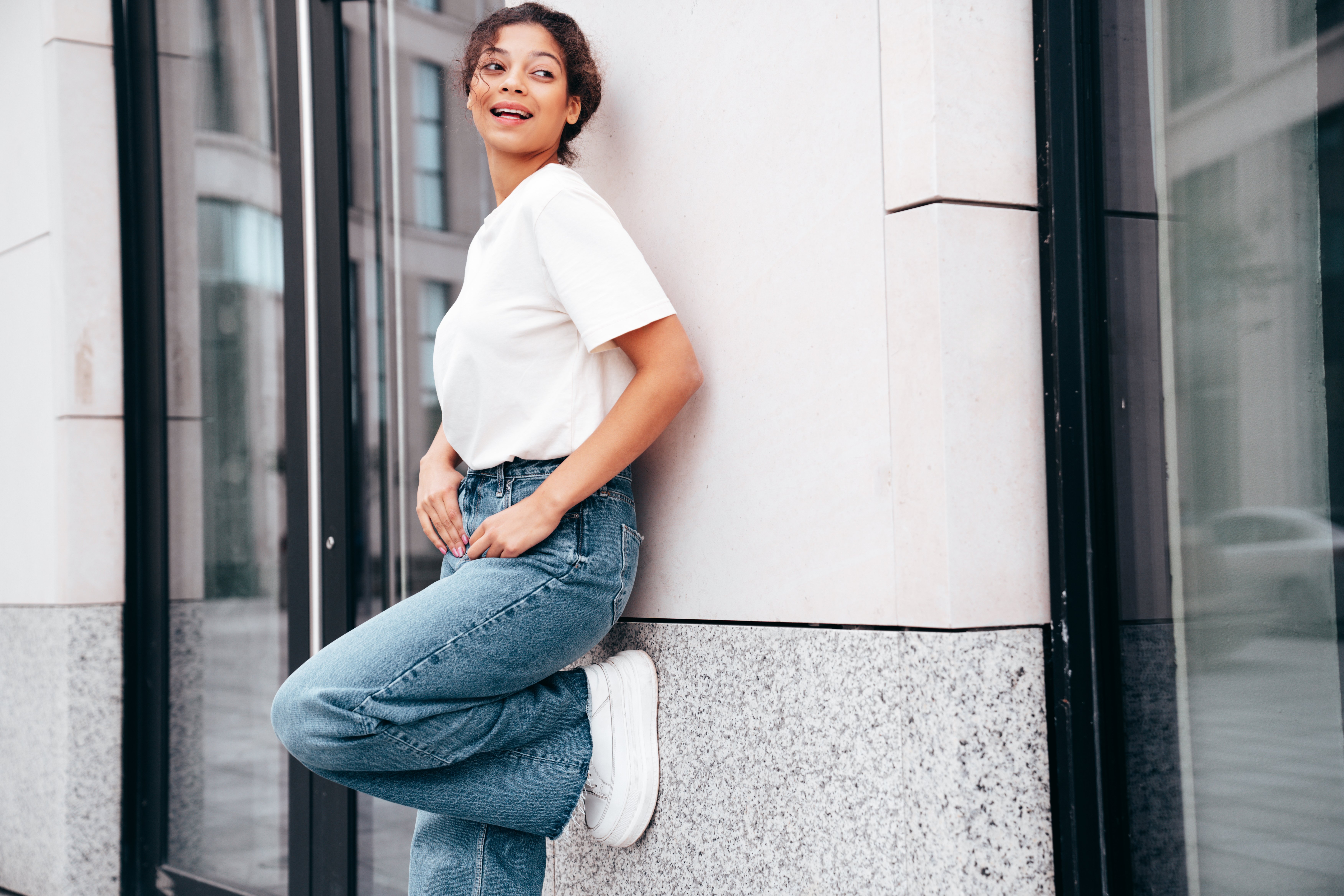 joven-hermosa-mujer-sonriente-en-camiseta-blanca-de-verano-casual-y-ropa-de-vaqueros-posando-al-aire-libre-1